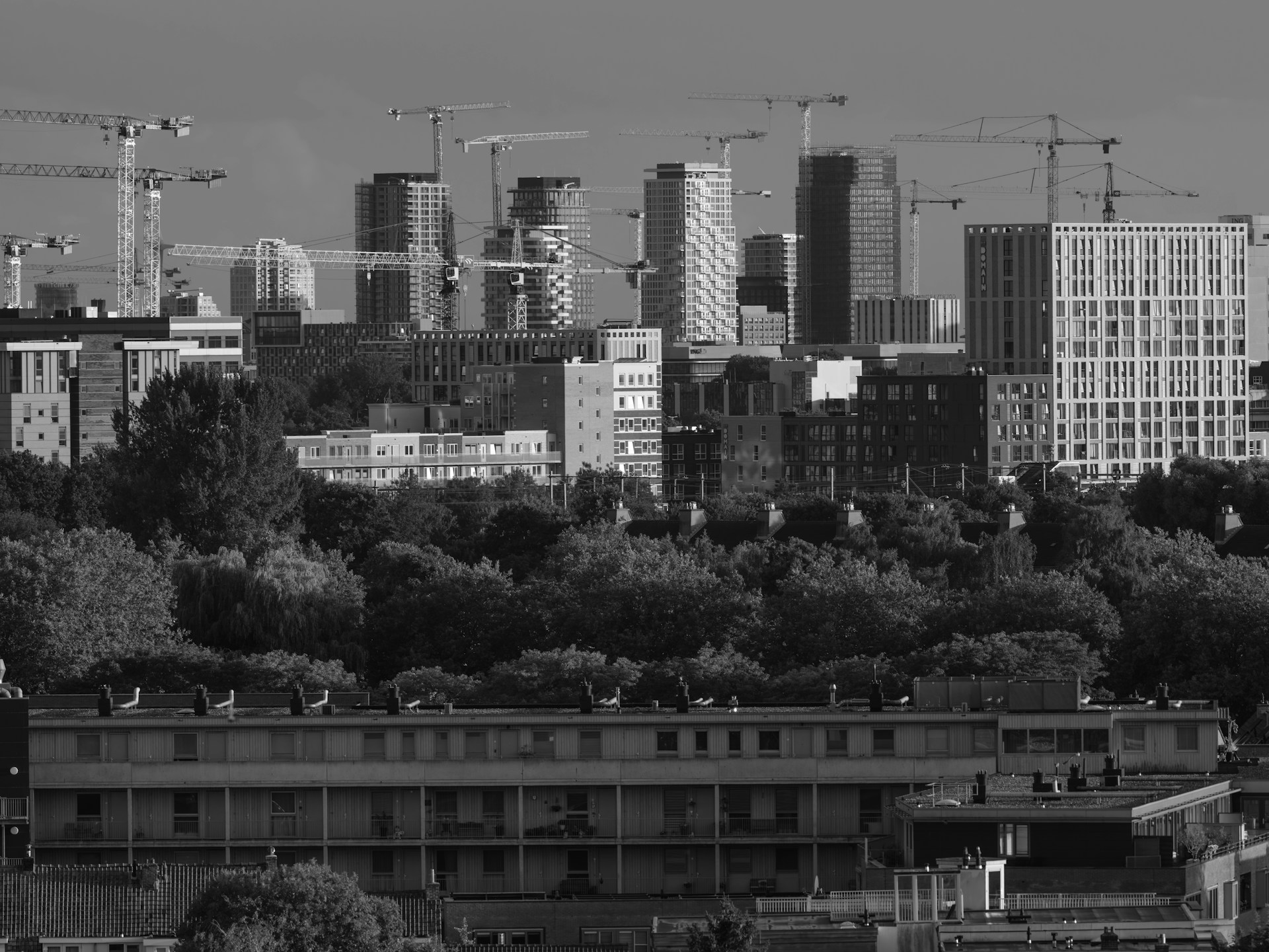 City skyline with construction cranes over new residential towers