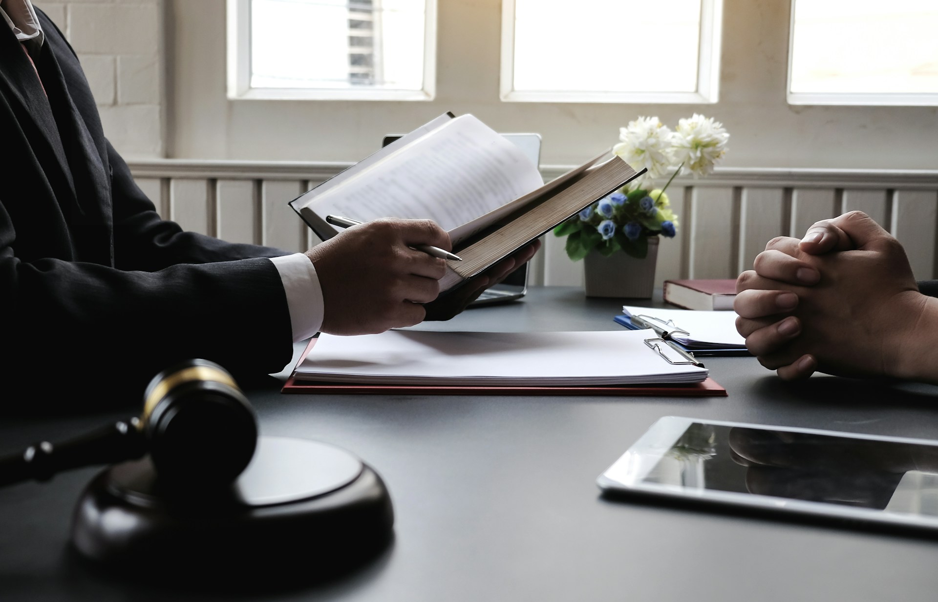 Legal consultation on regulatory compliance requirements, with a lawyer reviewing documentation for a client