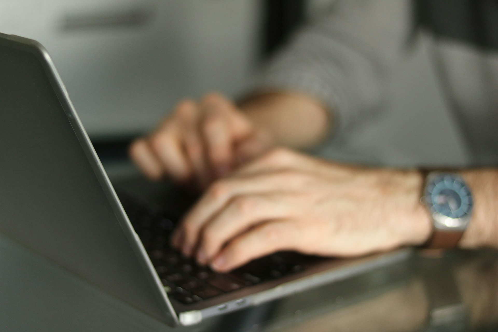 Hands typing on a laptop keyboard, representing an investor managing digital property interests.
