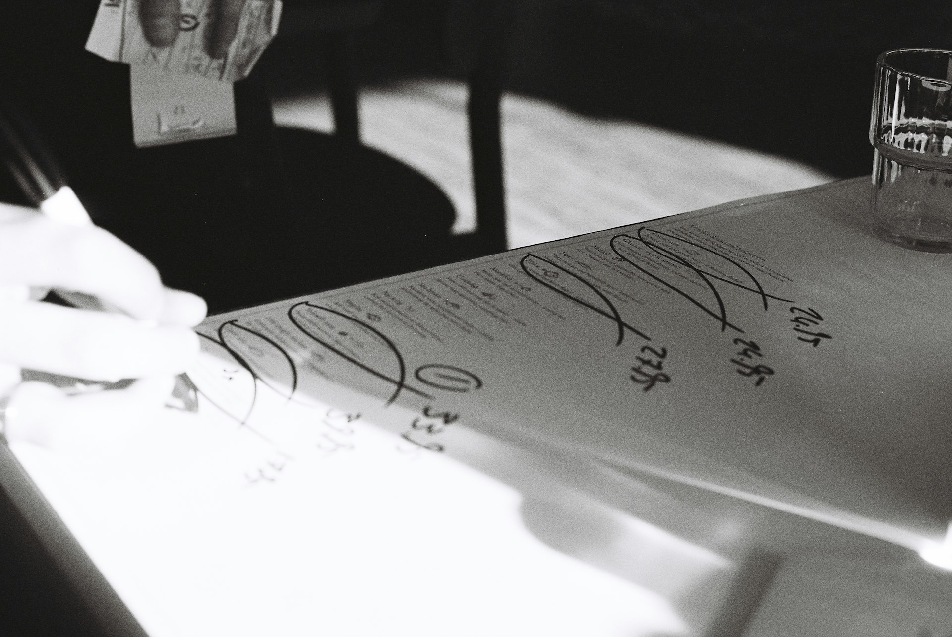 Hands signing legal documents on a table, symbolizing property transactions.