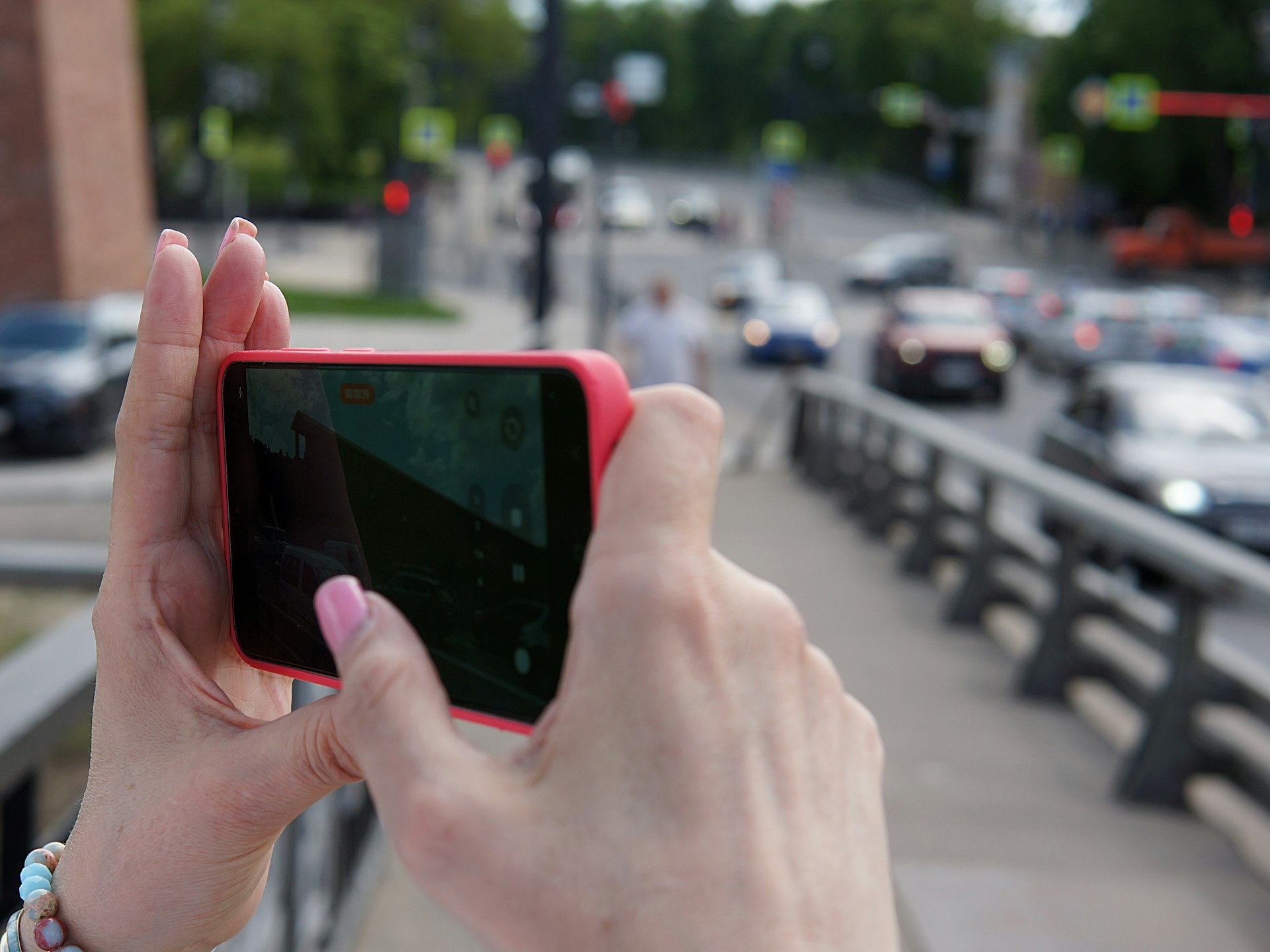 Hands holding a smartphone with a blurred city background, representing investor access and marketplaces.