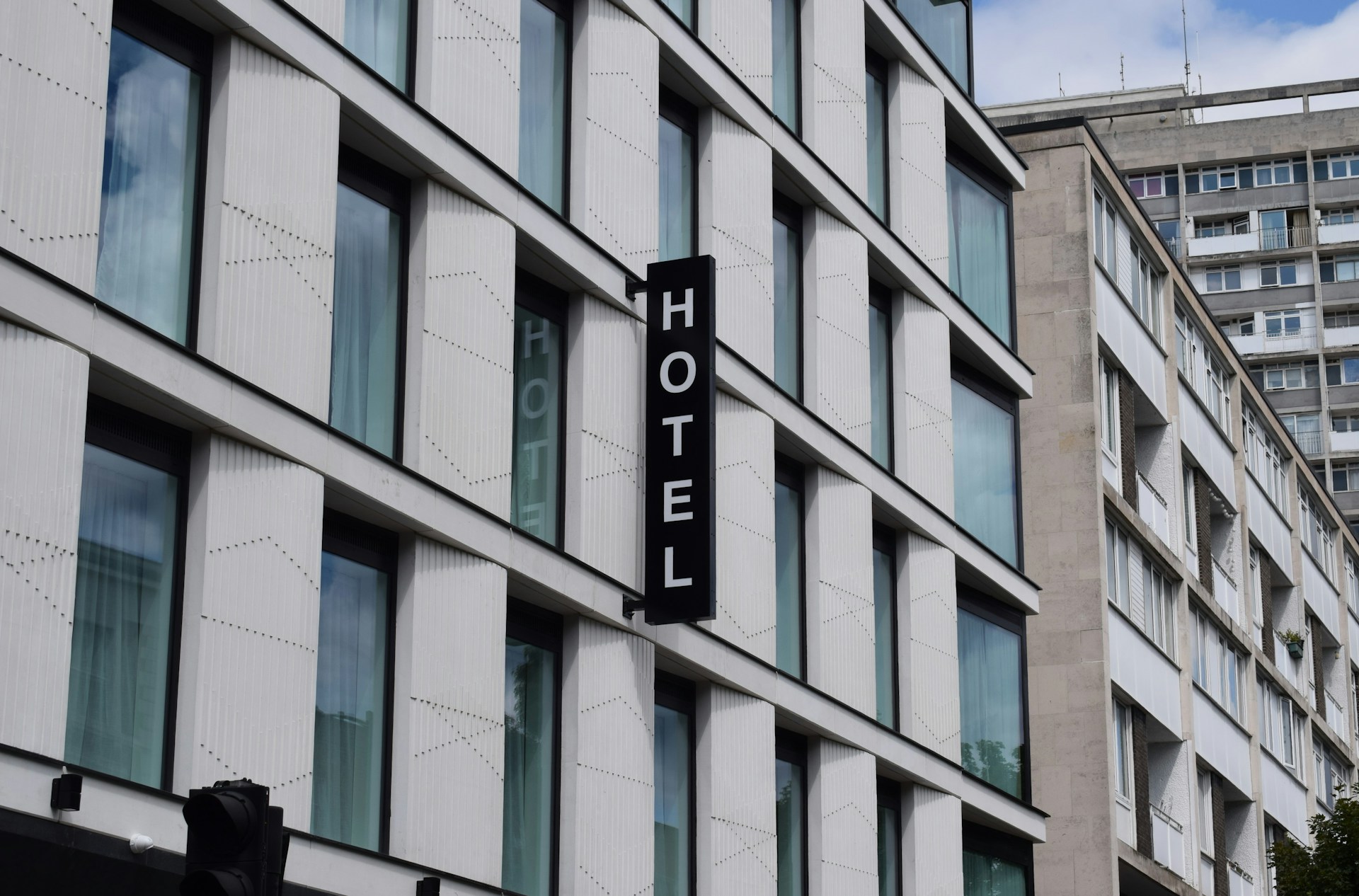 Facade of an urban hotel with a vertical HOTEL sign
