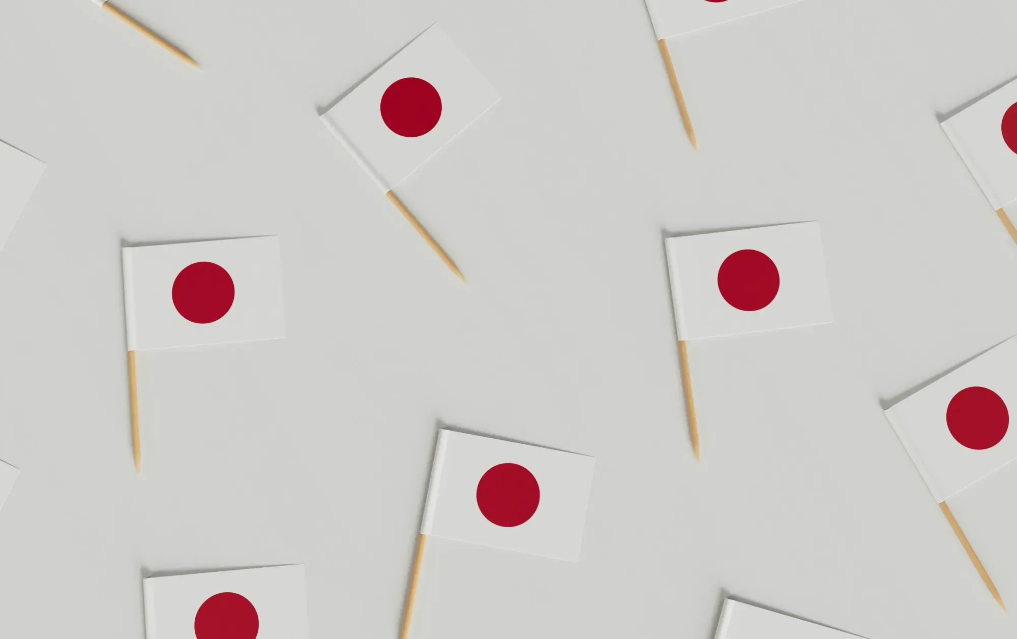 Japanese flag with Mount Fuji in background – national flag of Japan waving on a pole with inscriptions, set against the snow-capped peak of Mount Fuji.