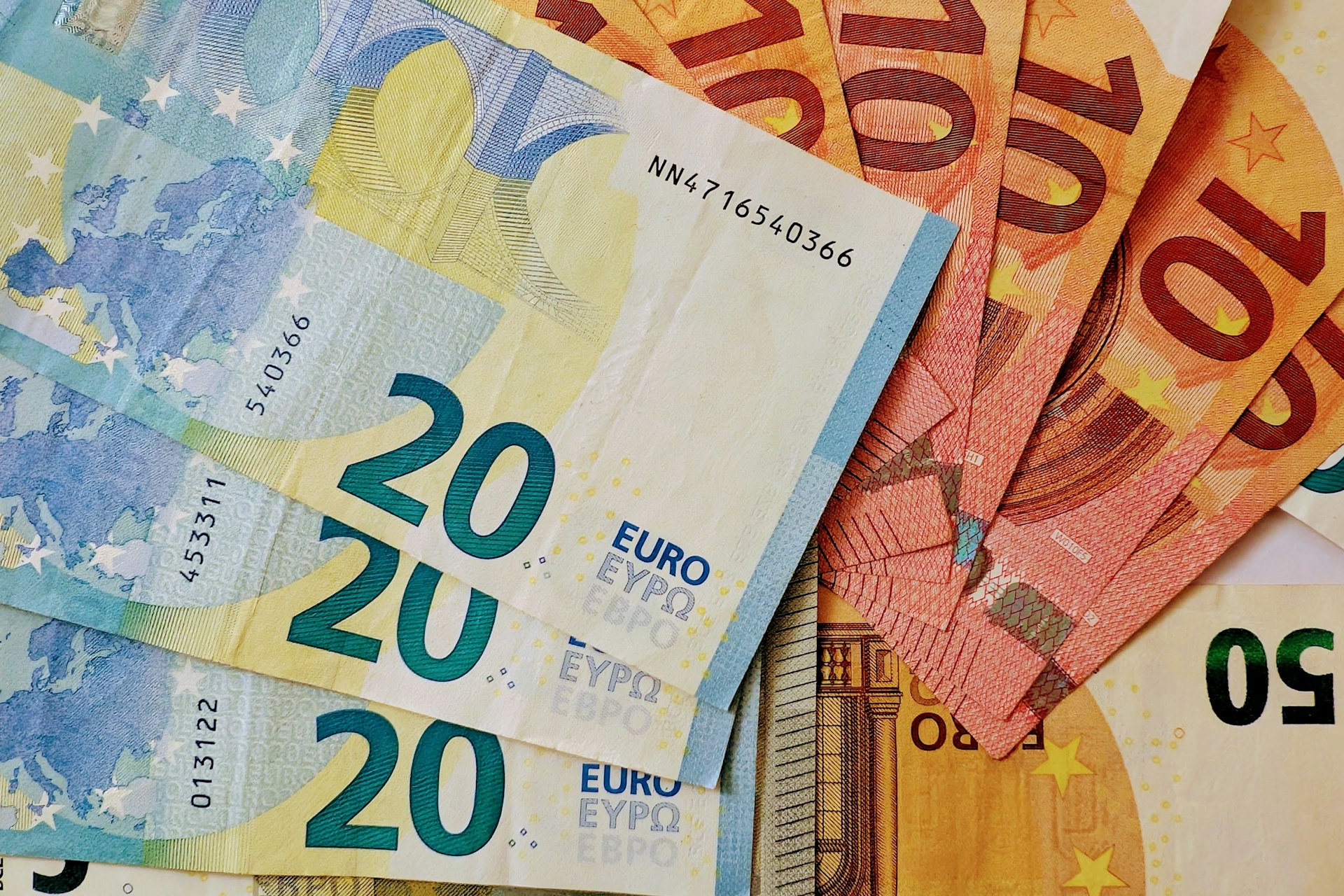 Stack of euro banknotes and coins, representing financial value.