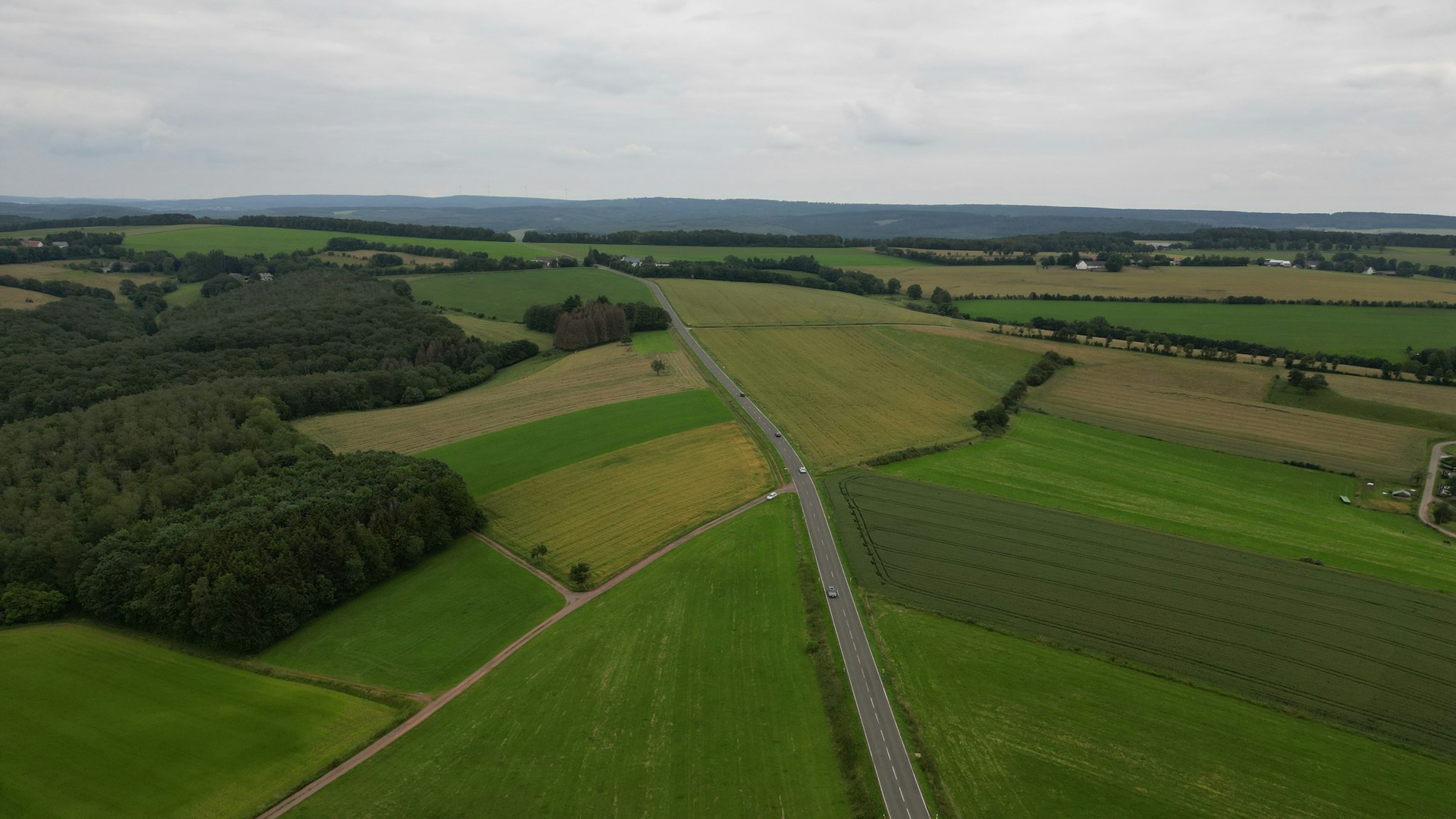 Aerial view of a road running through undeveloped green farmland