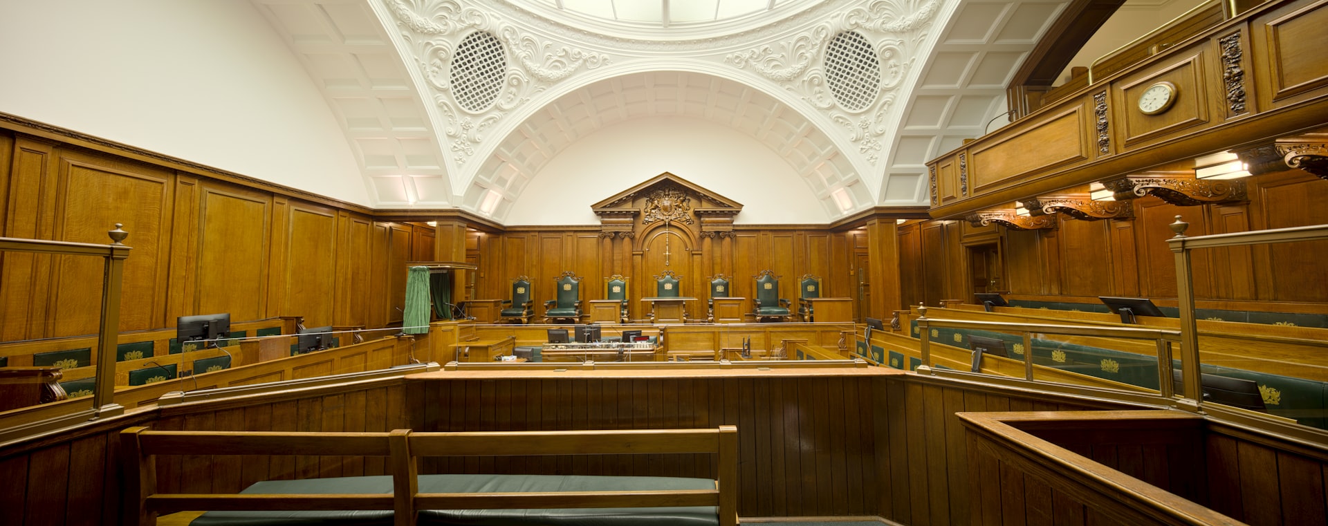 A gavel and law books in a courtroom setting, symbolizing compliance.