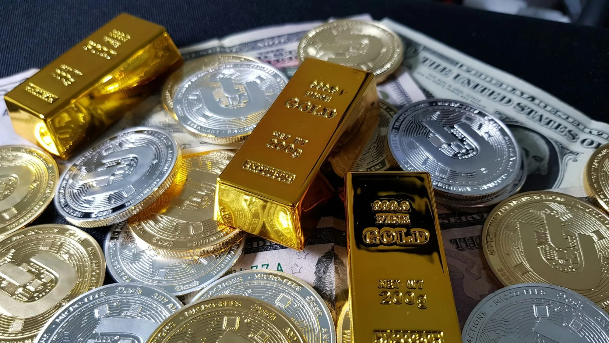 Gold bullion bars stacked on US dollar banknotes representing the intersection of physical gold and digital tokenized assets